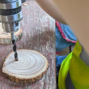 Kind beim Sägen und Werken mit Holz in der Naturwerkstatt